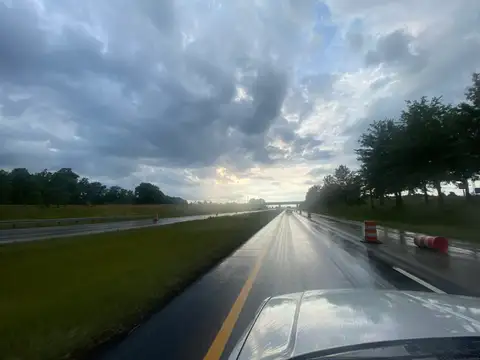 Wet pavement mirrors a dramatic sky.